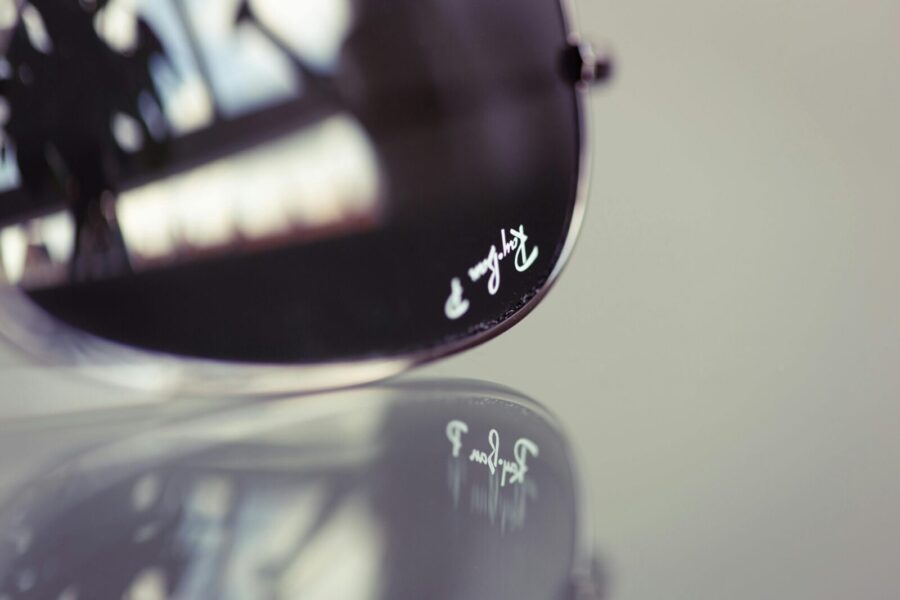 A detailed image of a pair of aviator sunglasses with brand reflection.