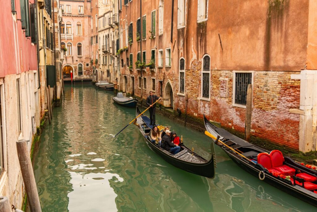 Gondolas on a charming Venetian canal surrounded by historic architecture in Venice, Italy.