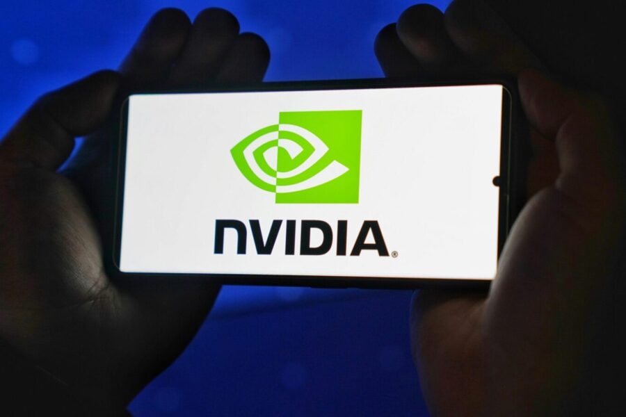 Hands holding a smartphone showing the NVIDIA logo on a bright screen.