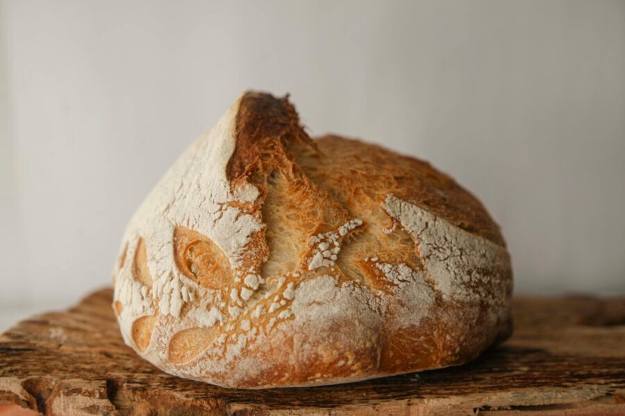 Close-up of freshly baked artisan sourdough bread on a rustic wooden board.