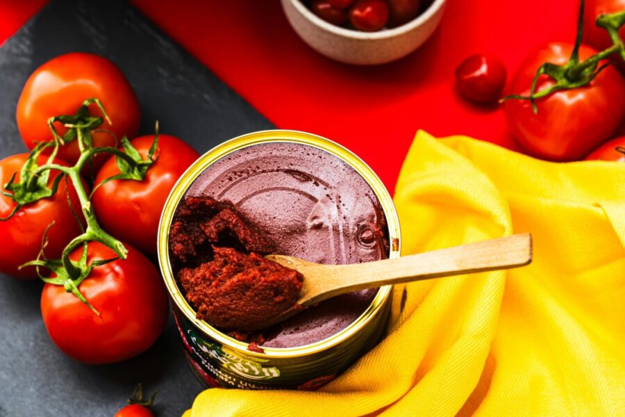 A colorful flat lay of fresh tomatoes and tomato paste in a bright and artistic presentation.