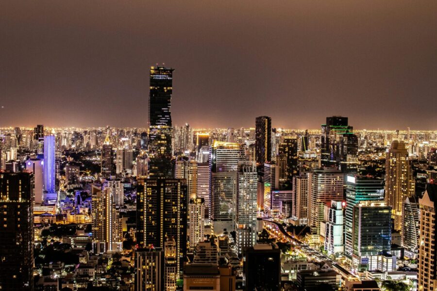 A vibrant night view of Bangkok's illuminated skyline featuring modern skyscrapers.