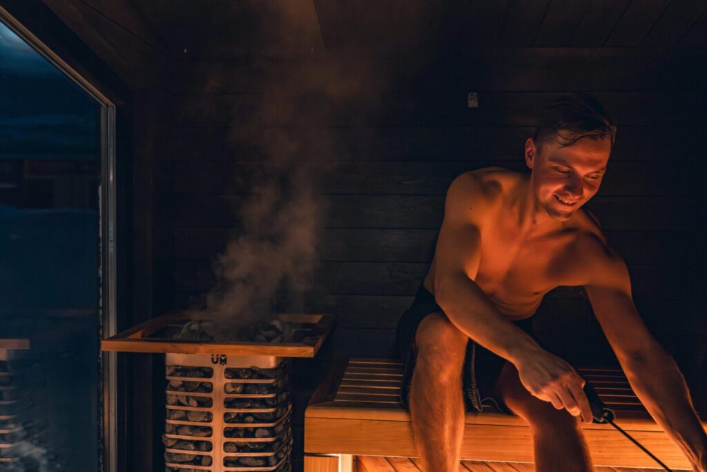 A man enjoying a warm and relaxing sauna session, embracing Nordic design.