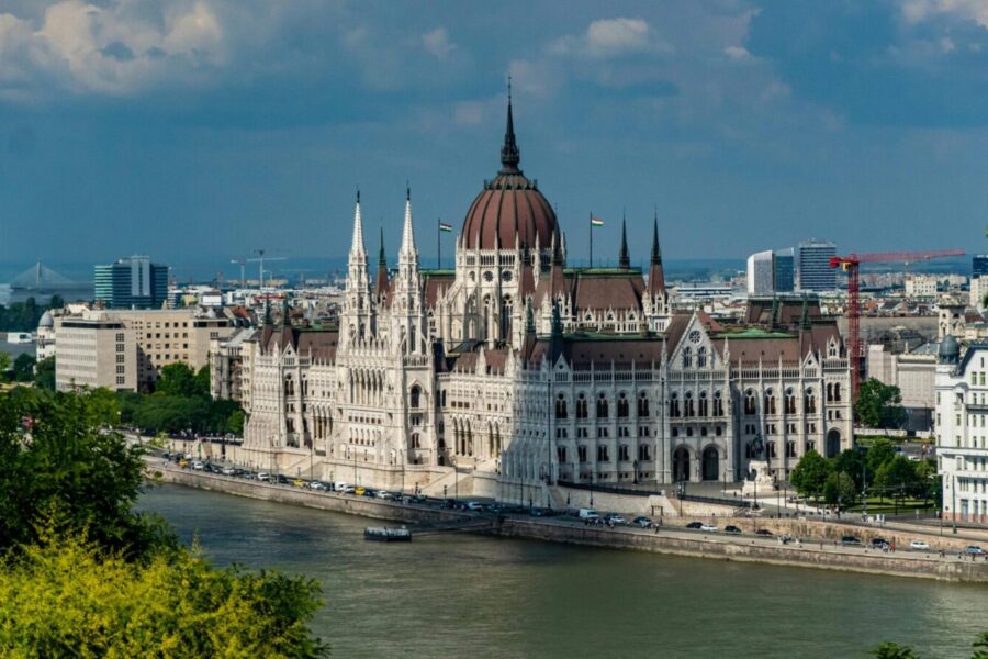 Scenic view of Budapest's iconic Parliament Building beside the Danube River, showcasing Gothic Revival architecture.