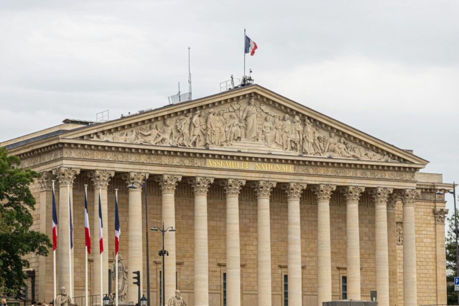 The majestic facade of the Assemblee Nationale in Paris, showcasing classic architecture.