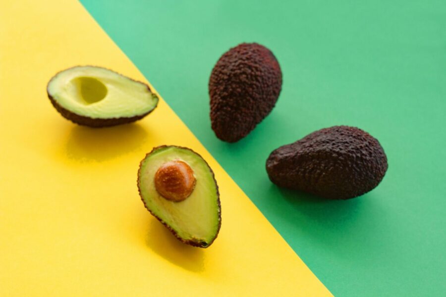 Ripe avocados displayed on a vibrant yellow and green background, perfect for food-related designs.