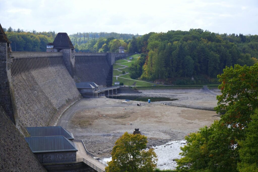 Aerial view of Edersee Dam surrounded by lush woodland and serene landscape in Germany.