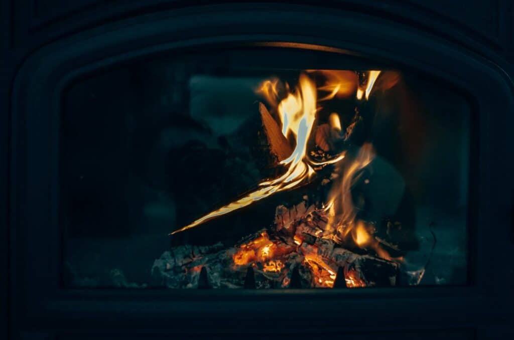 Warm close-up of a fireplace with fire burning logs, creating a cozy atmosphere.