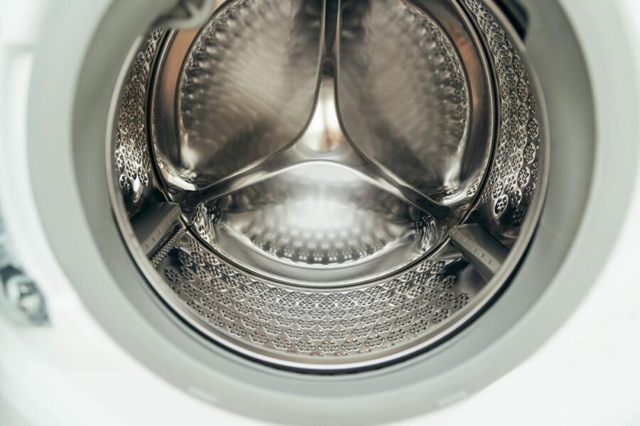 Detailed view of a clean, modern washing machine drum, showcasing shiny stainless steel interior.