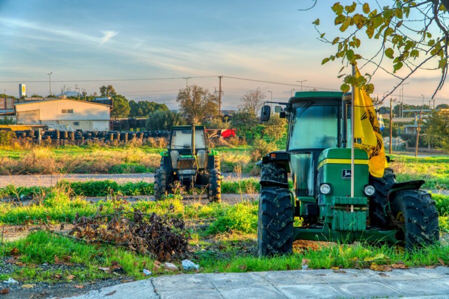 Green tractors in a picturesque rural scene in Schimatari, Greece at dawn.