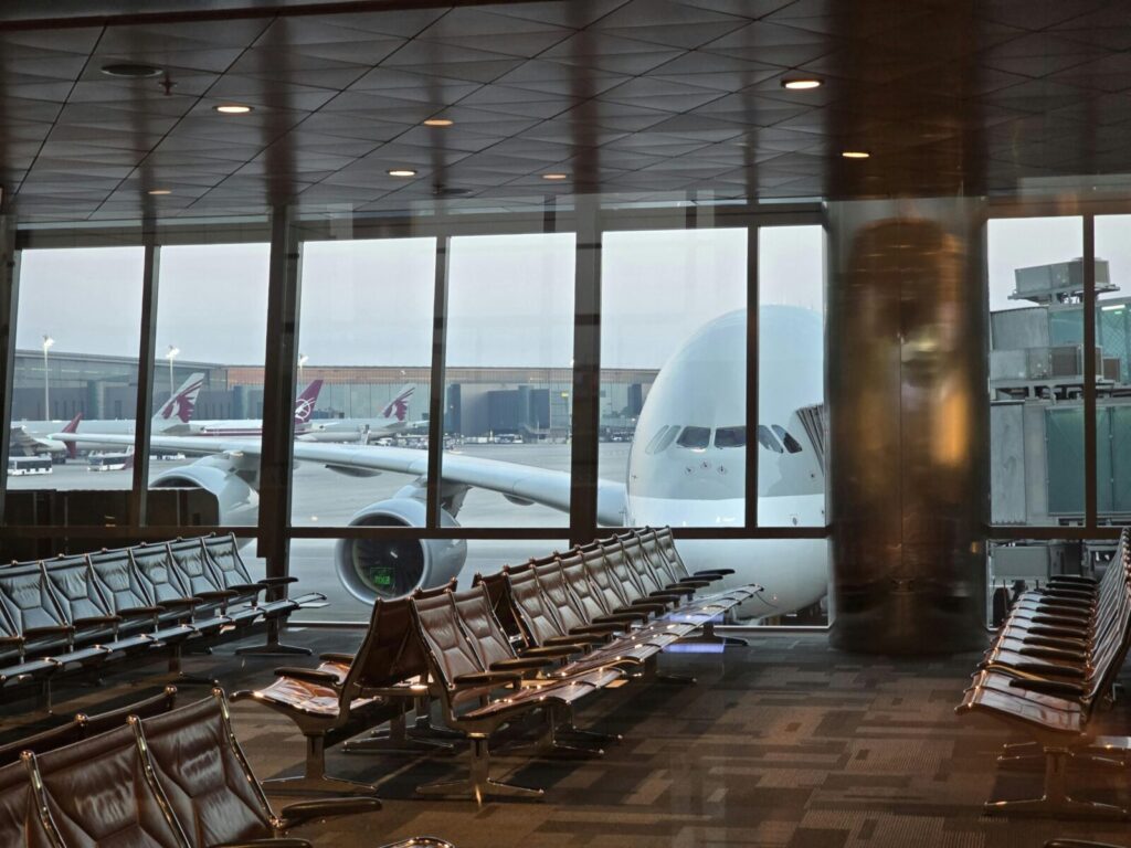 A passenger plane at Hamad International Airport in Doha with empty seating area in the foreground.