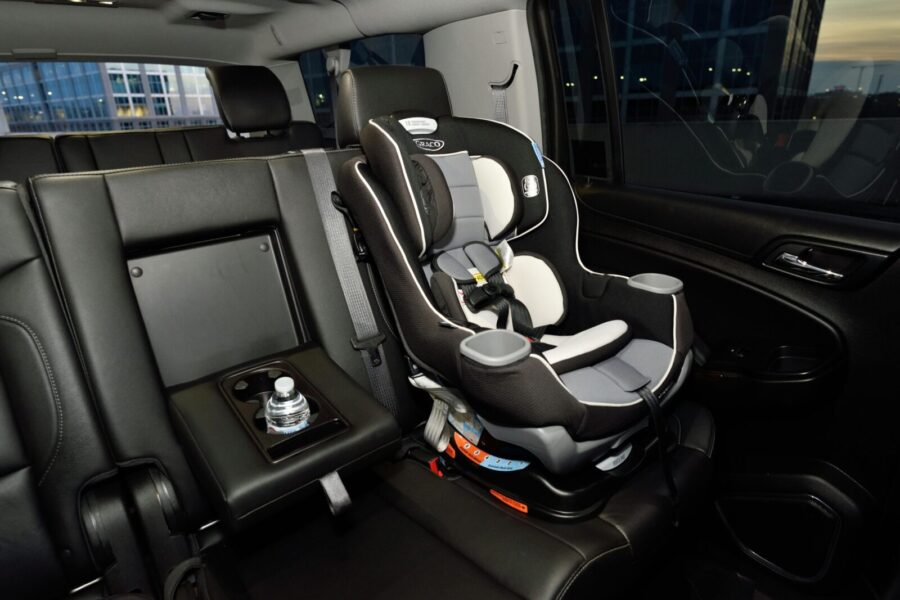 Safety car seat securely installed in the back of a modern vehicle. Ideal for family travel.