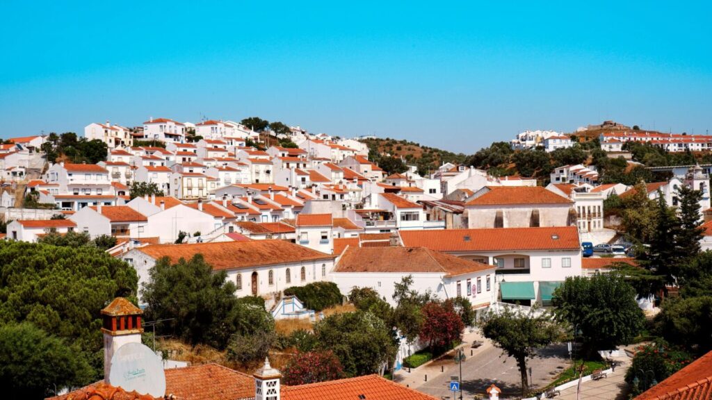 Charming view of Odemira, Portugal with iconic white buildings and red roofs on a sunny summer day.