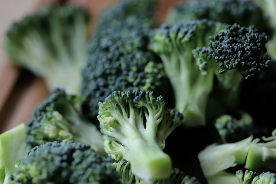 Close-up of fresh green broccoli florets on a kitchen chopping board, ready for cooking.