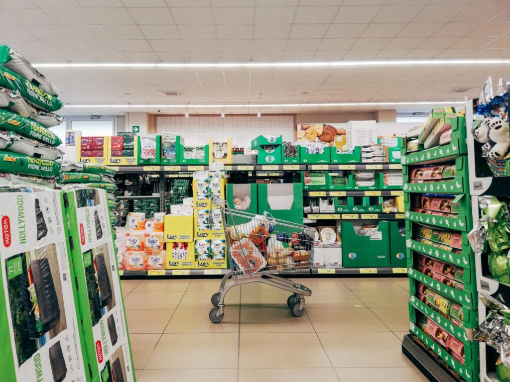 Shopping cart in a vibrant supermarket aisle in Padova, Italy.