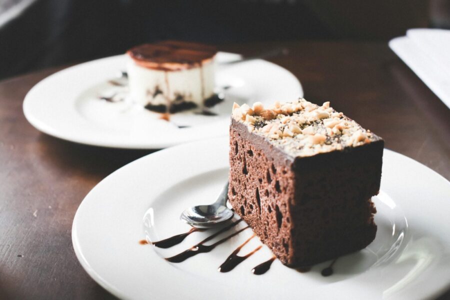 Indulgent chocolate and tiramisu desserts on plates with chocolate drizzle.