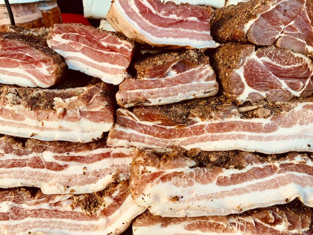 High-quality image of stacked raw pork belly slices, seasoned and ready for cooking.