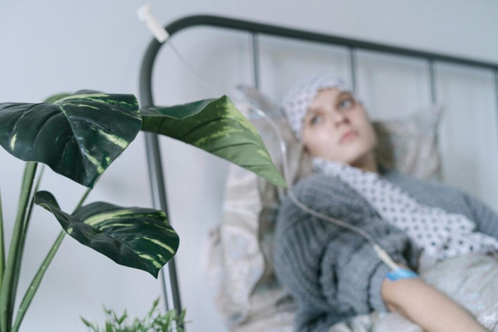 A cancer patient with an IV drip lies on a hospital bed, reflecting hope and recovery.