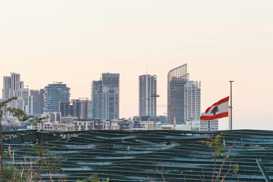 Captured view of Beirut's skyline with the Lebanese flag during sunset, showcasing urban architecture.