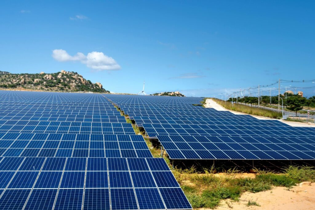 A vast array of solar panels under a clear blue sky, symbolizing renewable energy and sustainability.