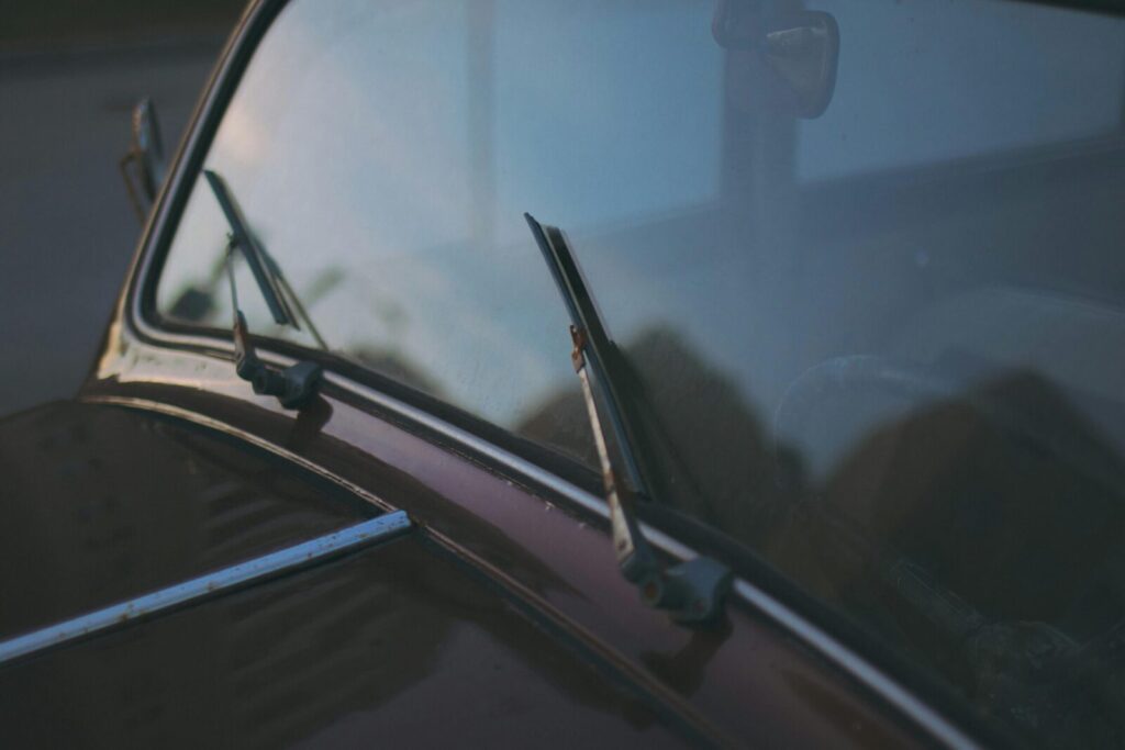 A detailed view of a vintage car's windshield and wipers, capturing a classic automotive design.