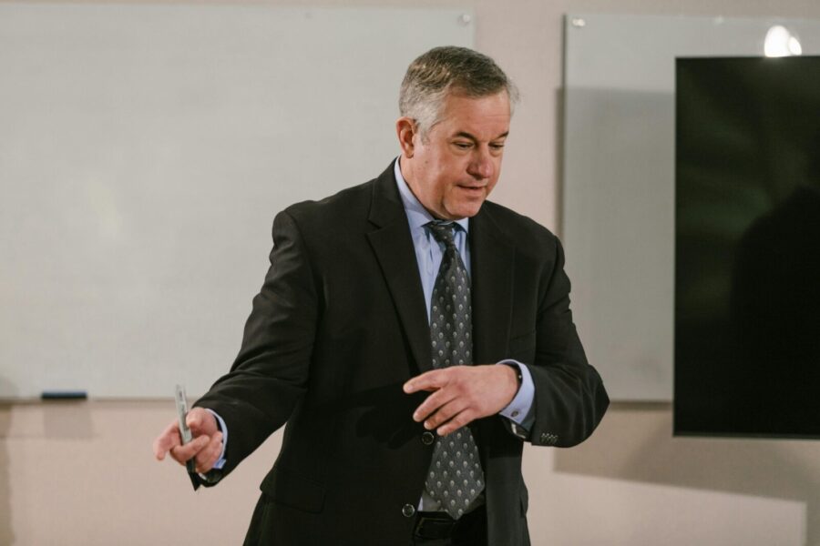 A business professional leading a presentation in a modern conference room.