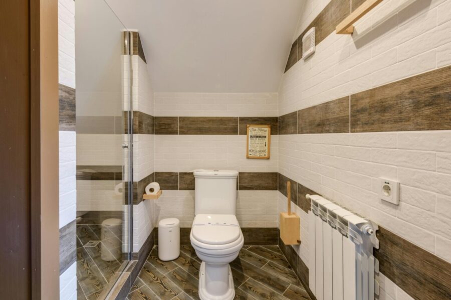 Minimalistic bathroom with clean white tiles and modern fixtures.