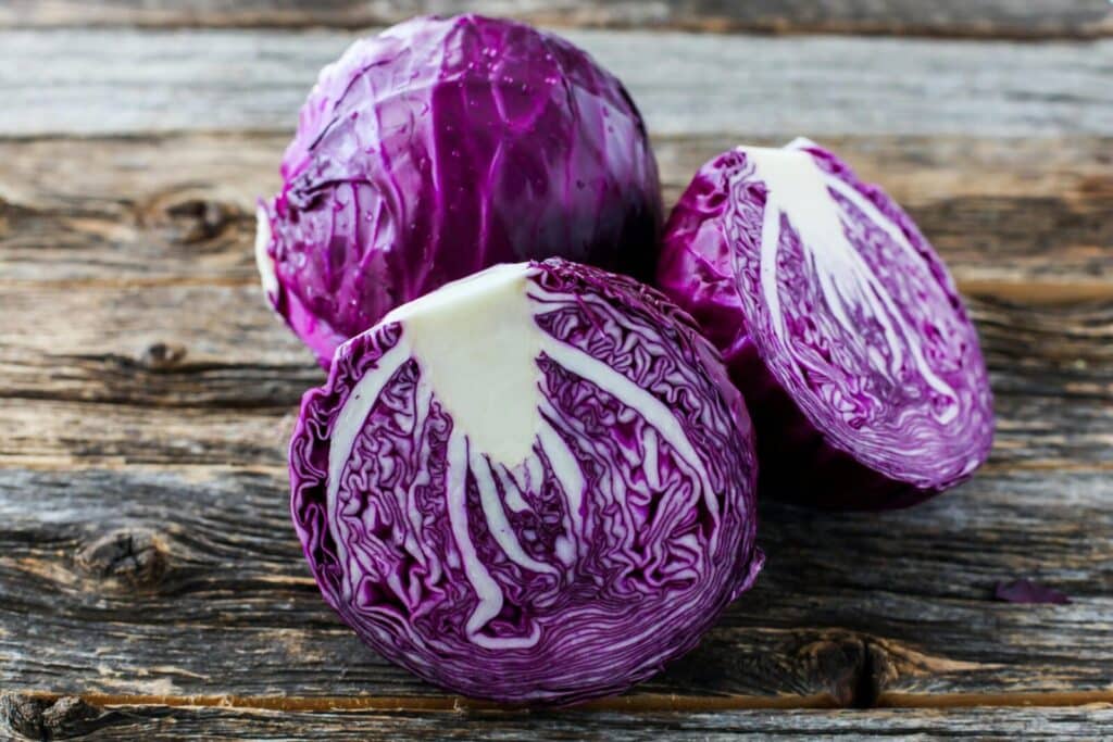 Close-up of detailed sliced red cabbage on rustic wooden surface.