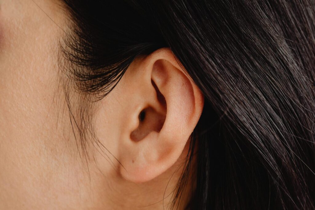 Detailed close-up photo showcasing a human ear with dark hair.