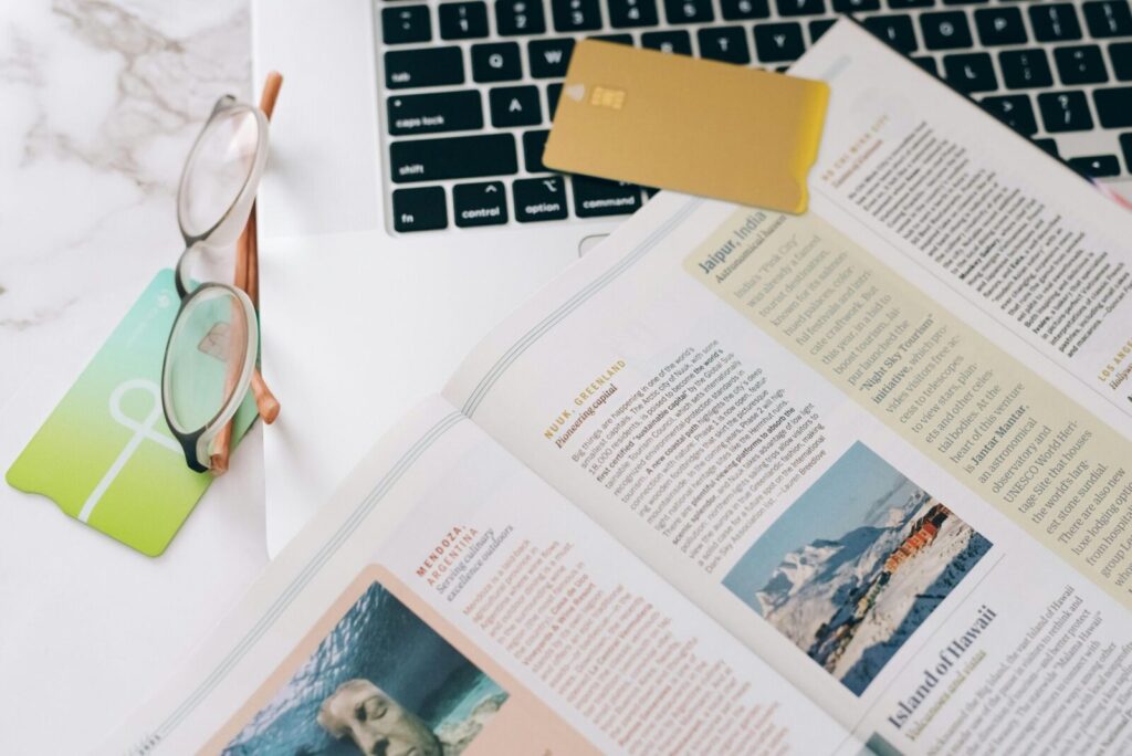 Close-up of a book, glasses, and laptop on a desk, ideal for education or productivity concepts.