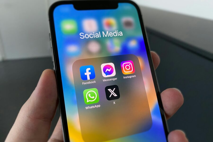 a person holding a cell phone with social media on the screen