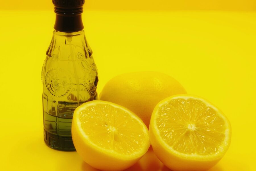 a bottle of water and two lemons on a yellow background