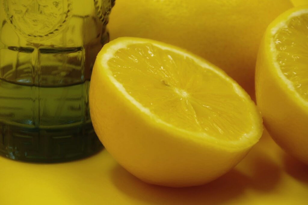 a close up of two lemons and a glass of water