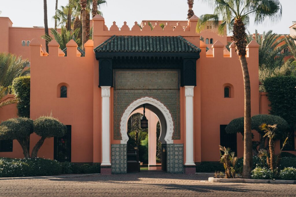 Moroccan architecture with ornate archway and palm trees