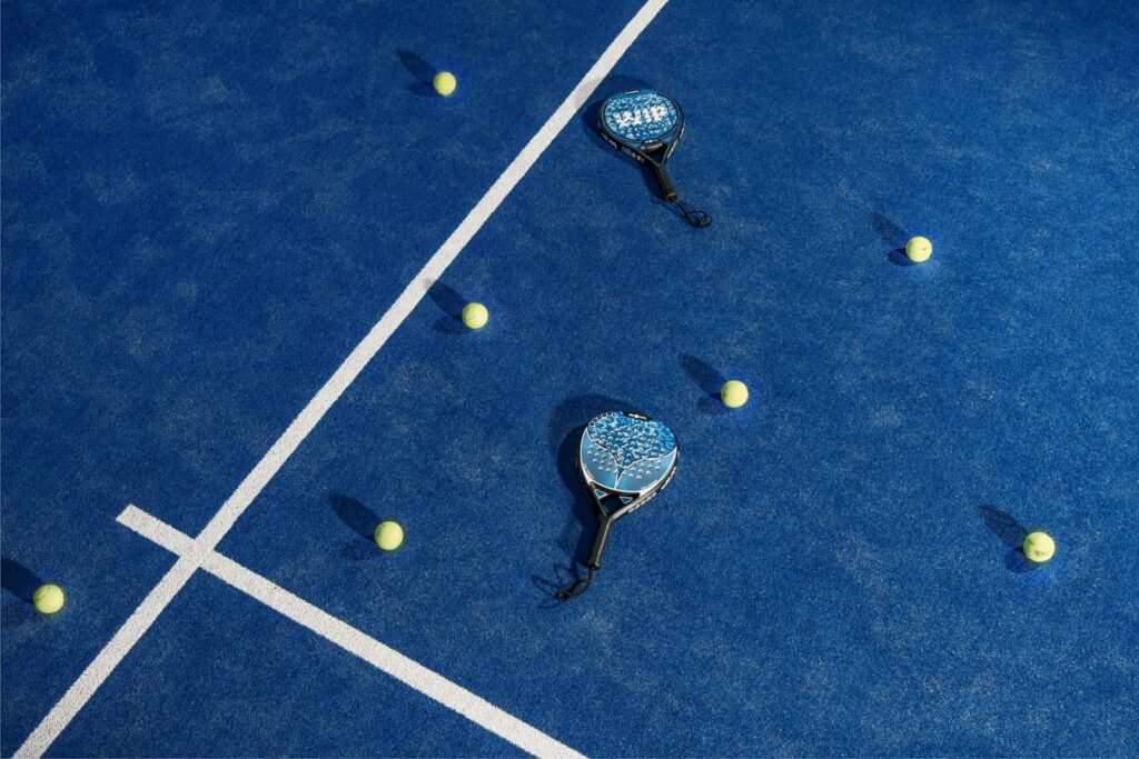 two tennis rackets and balls on a blue tennis court