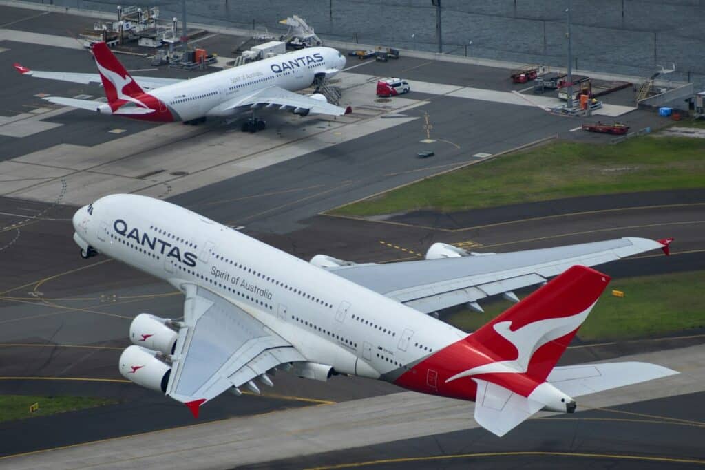 A large passenger jet flying over a runway