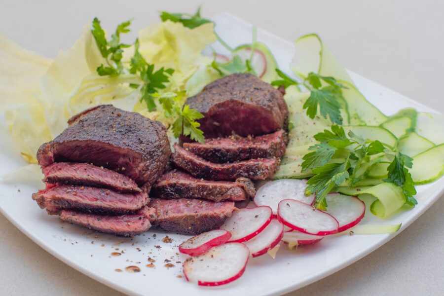 a white plate topped with meat and veggies