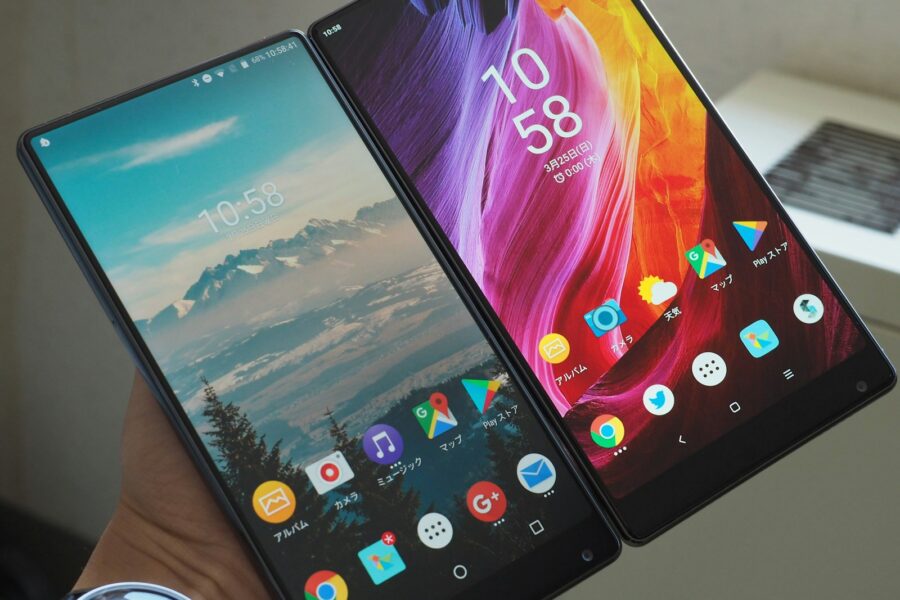 a person holding two cell phones in their hands