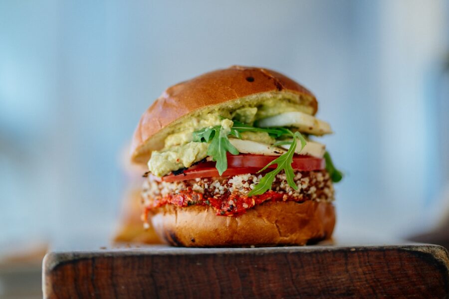selective focus photography of hamburger with sliced tomatoes and vegetables