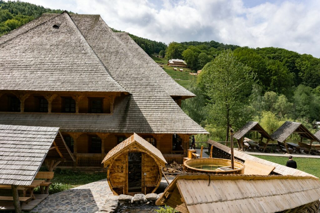 a wooden building with a water well in front of it