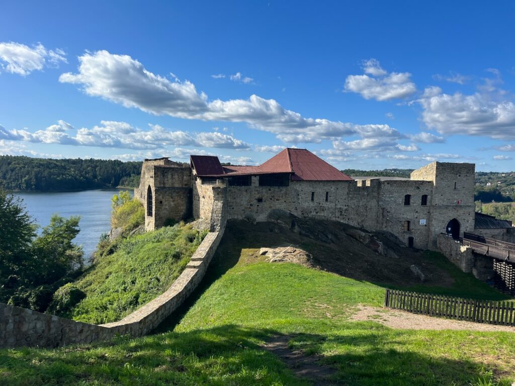A large castle sitting on top of a lush green hillside