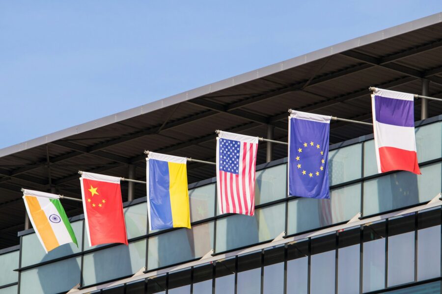 Flags of various nations fly on building.