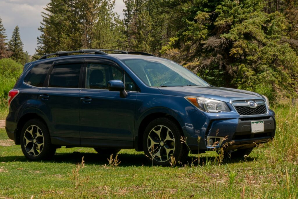 A blue subarunt parked in a grassy field