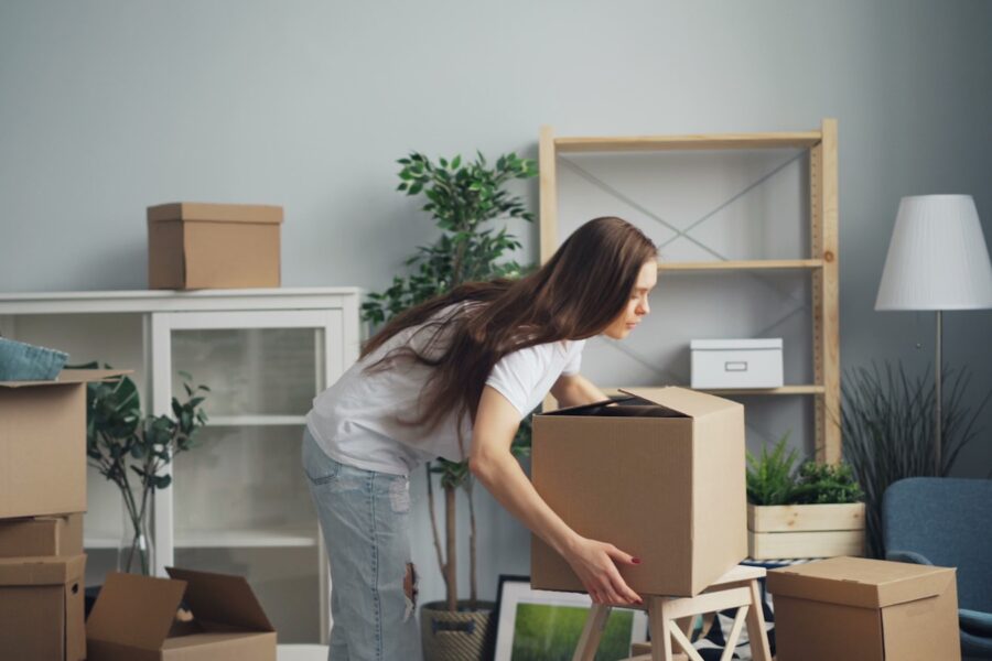 a woman moving boxes in a living room