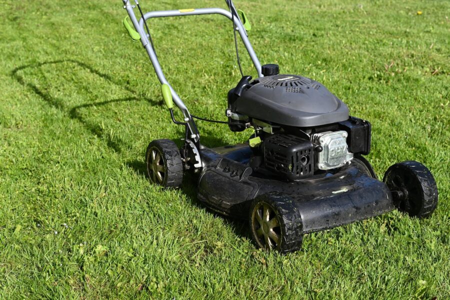 black and yellow push lawn mower on green grass during daytime
