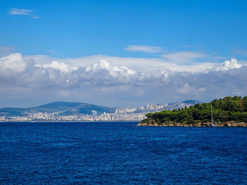 Panoramic view of Istanbul's coastline with deep blue sea and lush greenery under a bright sky.