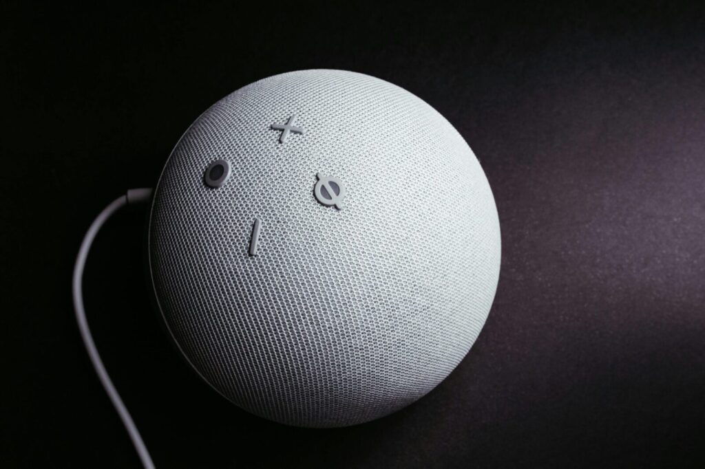 Close-up of a smart speaker on a black background, showcasing minimalistic elegance.