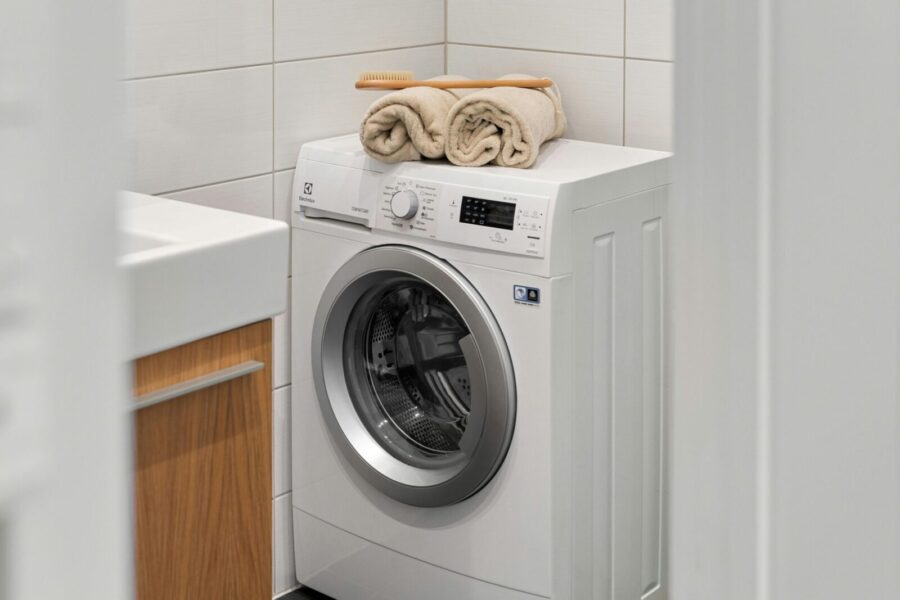 Stylish and clean laundry space featuring a white washing machine with towels on top.