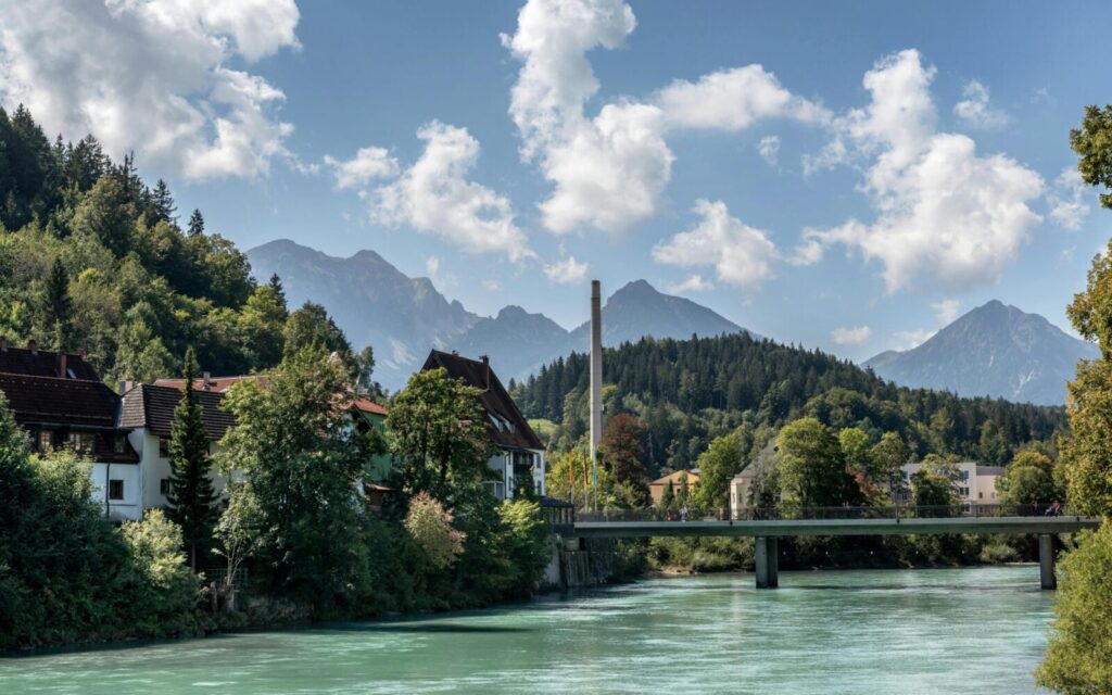 Picturesque landscape in Füssen, Germany with river, bridge, and alpine background.