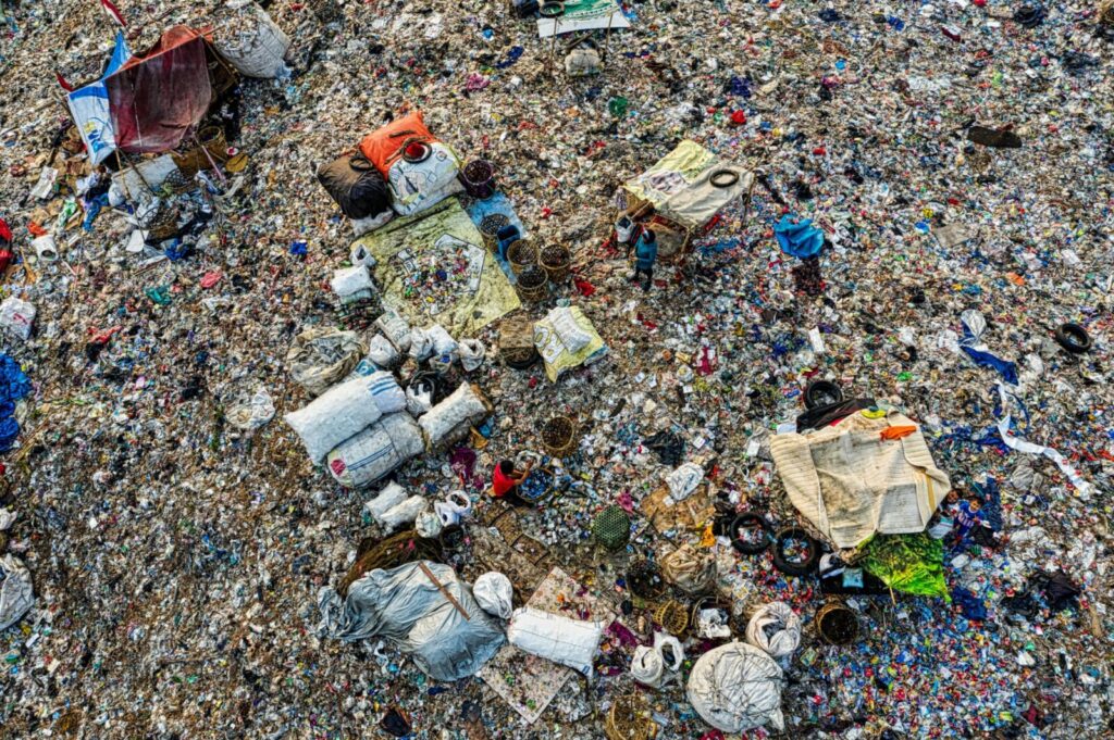 An aerial shot capturing the cluttered expanse of a landfill, showcasing pollution and waste management.